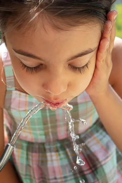 Çocuklar pınardan su içer. Seçici odaklanma. Doğa.