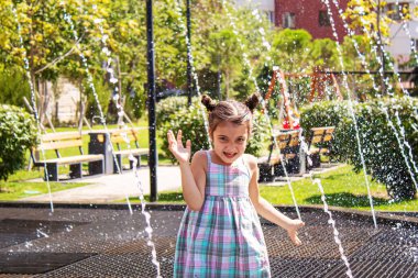 Mutlu çocuk çeşmede oynuyor. Seçici odaklanma. İnsanlar