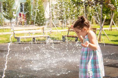 Mutlu çocuk çeşmede oynuyor. Seçici odaklanma. İnsanlar