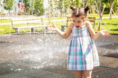 Mutlu çocuk çeşmede oynuyor. Seçici odaklanma. İnsanlar