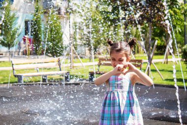 Mutlu çocuk çeşmede oynuyor. Seçici odaklanma. İnsanlar