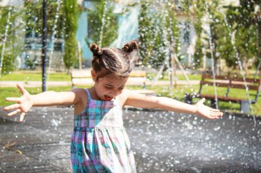 Mutlu çocuk çeşmede oynuyor. Seçici odaklanma. İnsanlar