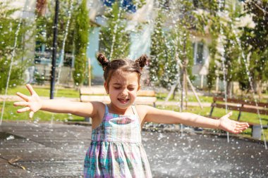 Mutlu çocuk çeşmede oynuyor. Seçici odaklanma. İnsanlar