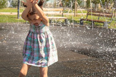 Mutlu çocuk çeşmede oynuyor. Seçici odaklanma. İnsanlar