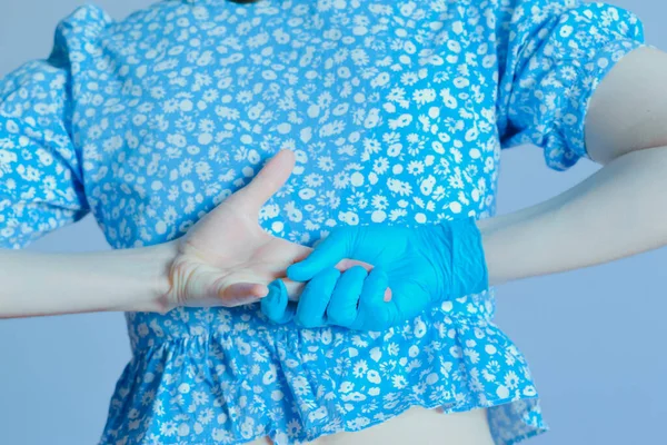 Eller arkada, biri mavi eldivenli, diğeri eldivensiz.