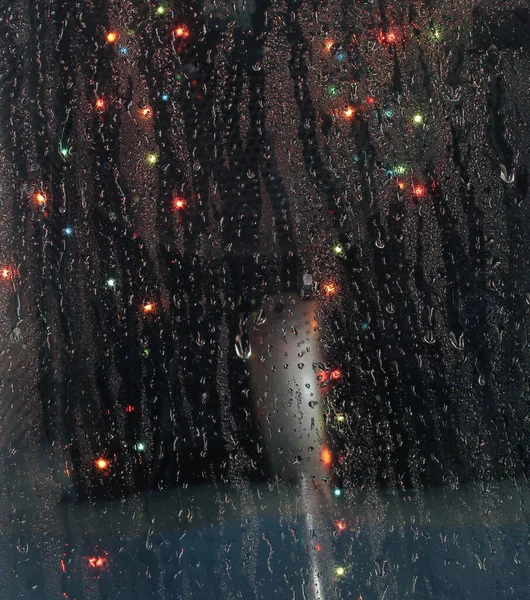 Bokeh ışıklarıyla pencere camında yağmur damlaları