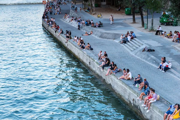 Birçok kişi Seine Nehri 'nin kıyısında oturuyor. Paris. Fransa. 2 Ağustos 2018.