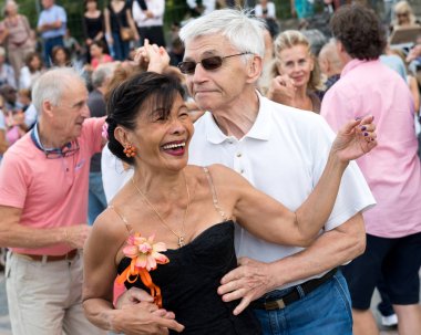 Paris'teki Seine Nehri'nin kıyısında dans eden yaşlı insanlar. 10 Ağustos 2019 Paris, Fransa. 