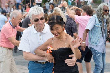 Paris'teki Seine Nehri'nin kıyısında dans eden yaşlı insanlar. 10 Ağustos 2019 Paris, Fransa. 