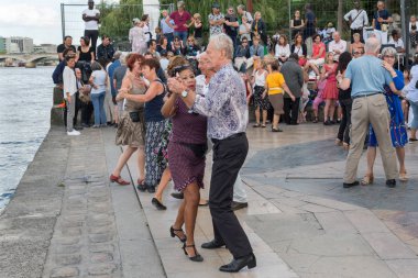Paris'teki Seine Nehri'nin kıyısında dans eden yaşlı insanlar. 10 Ağustos 2019 Paris, Fransa. 