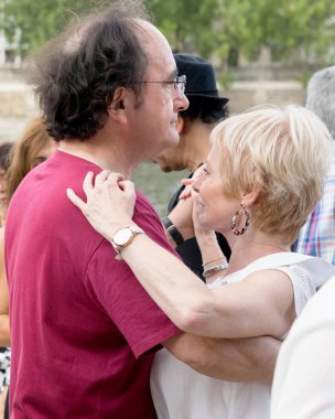 Paris'teki Seine Nehri'nin kıyısında dans eden yaşlı insanlar. 10 Ağustos 2019 Paris, Fransa. 