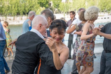 Paris'teki Seine Nehri'nin kıyısında dans eden yaşlı insanlar. 10 Ağustos 2019 Paris, Fransa. 