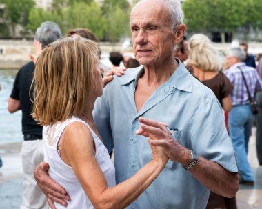 Paris'teki Seine Nehri'nin kıyısında dans eden yaşlı insanlar. 10 Ağustos 2019 Paris, Fransa. 