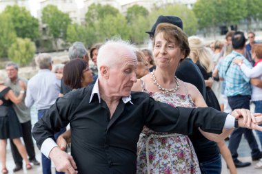 Paris'teki Seine Nehri'nin kıyısında dans eden yaşlı insanlar. 10 Ağustos 2019 Paris, Fransa. 