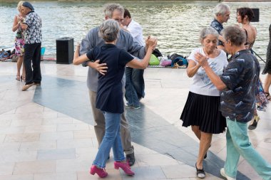 Paris'teki Seine Nehri'nin kıyısında dans eden yaşlı insanlar. 10 Ağustos 2019 Paris, Fransa. 