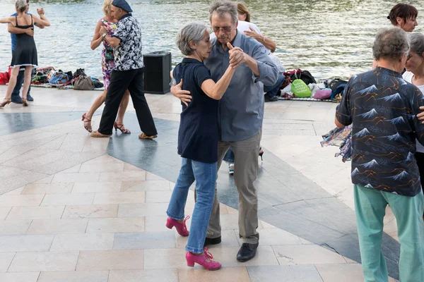Paris'teki Seine Nehri'nin kıyısında dans eden yaşlı insanlar. 10 Ağustos 2019 Paris, Fransa. 