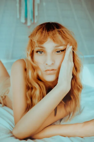 迷人的红头发模特躺在有白色窗帘的平房床上 年轻性感模特完美身材的肖像 — 图库照片