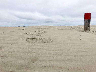 Hollanda, Terschelling 'deki Northsea sahilinde tahta kırmızı plaj direği.