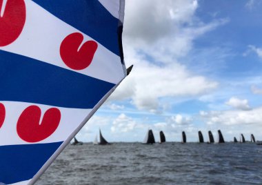 Friesland, Hollanda 'da arka planda skutsjesilen olan Frizya bayrağı