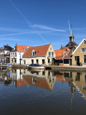 Eski Makkum, Friesland, Hollanda 'da bir kanalın yanındaki evler.