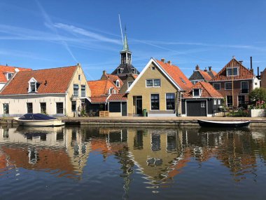 Eski Makkum, Friesland, Hollanda 'da bir kanalın yanındaki evler.