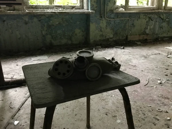 ウクライナ北部のゴーストタウンプリピャトの学校のテーブルの上のガスマスク — ストック写真