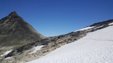 Norveç 'in Jotunheimen Ulusal Parkı' nda karlı yürüyüş yolu
