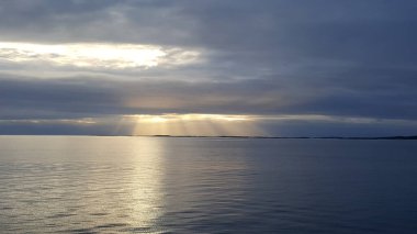 Norveç 'te bulutların arasından gün batımı güneşi