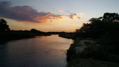 Namibya, Divundu 'daki Popa Game Park' ın etrafındaki Okavango Nehri 'nde gün batımı