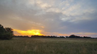 Namibya 'daki Mudumu Ulusal Parkı' nda bulutlu gün batımı