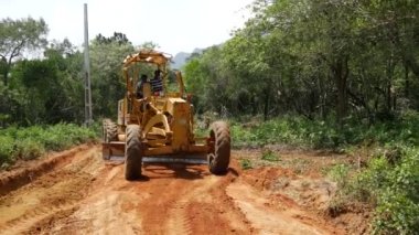Sri Lanka 'da toprak bir yolda büyük bir kamyonla çalışan adamlar.