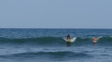 Arugam Körfezi Sri Lanka 'da dalga sörfü yapan adam.