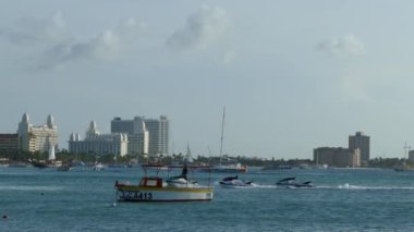 Kuzey Aruba 'daki kumsala jet ski çekiyoruz. Beackground' daki otelin silueti var.