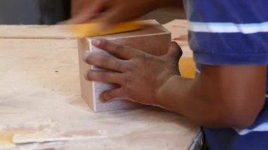 Esteli Nikaragua 'da bir puro fabrikasında ahşap bir puro kutusu zımparalıyorum.