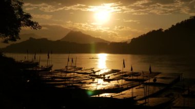 Luang Prabang, Laos, Asya 'daki Mekong Nehri' nde uzun kuyruklu teknelerle gün batımı