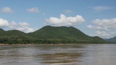 Mekong Nehri manzarasında bir tekneyle, Laos