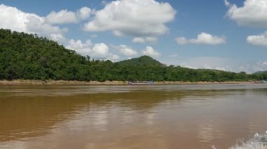 Mekong Nehri manzarasında bir tekneyle, Laos