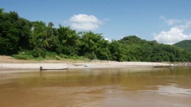 Mekong Nehri manzarasında bir tekneyle, Laos