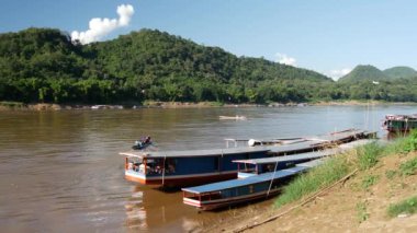 Yerel halk uzun kuyruklu bir tekneyle Luang Prabang, Laos 'taki Mekong nehrinden ayrılıyor.