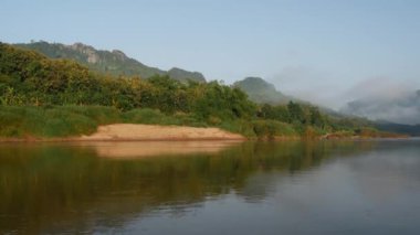 Laos 'taki sisli dağlarla sabah nehirde