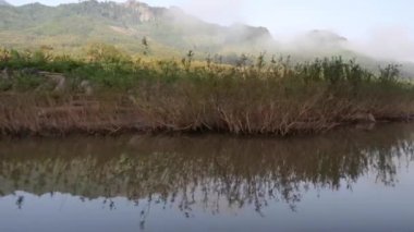 Sabah sisli dağların Laos 'taki sularda yansımasıyla