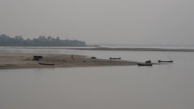 Ayeyarwady nehrinde küçük balıkçı kulübeleri olan nehir kenarı, Myanmar, Burma