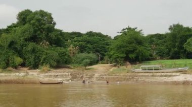 Ayeyarwady nehrinde küçük bir balıkçı teknesi olan nehir kenarı, Myanmar, Burma
