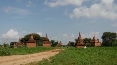 Bagan, Myanmar, Burma 'dan geçen elektro motorlu bir adamla Pagodas manzarası
