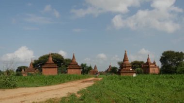 Bagan, Myanmar, Burma 'dan geçen elektro motorlu bir adamla Pagodas manzarası