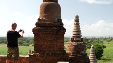 Adam cep telefonuyla fotoğraf çekiyor. Bagan, Myanmar, Burma 'daki Pagoda' dan.