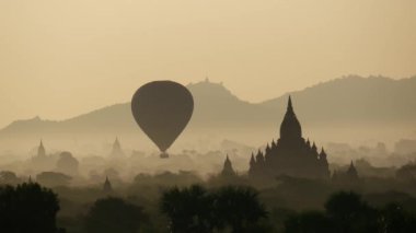 Bagan, Myanmar, Burma 'daki Pagodas' ın üzerinde gün doğumunda uçan balon.