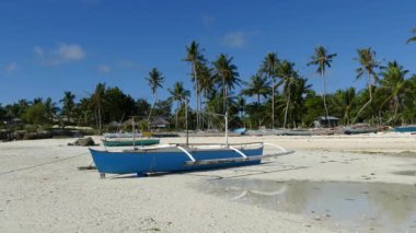 Filipinler 'deki Bohol Adası' ndaki alçak gelgit sırasında sabah Anda sahilinde yansıyan mavi katamaran teknesi.