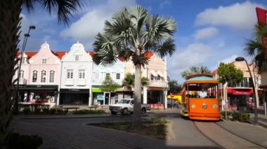 Oranjestad Aruba 'dan geçen turuncu tramvay.