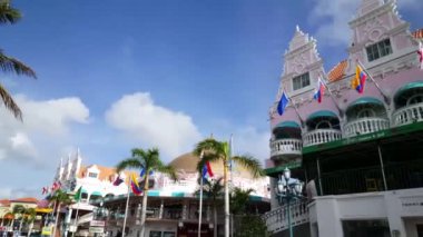 Oranjestad Aruba 'daki renkli Royal Plaza alışveriş merkezinin önünde yürüyorum.